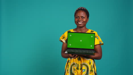 Confident-smiling-woman-presenting-a-chroma-key-display-on-laptop