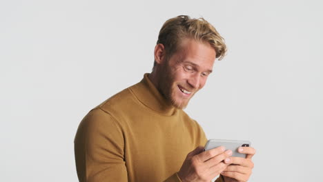 cheerful man using smartphone for playing