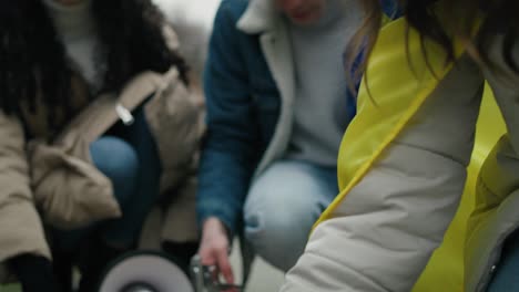 Group-of-young-caucasian-people-preparing-cardboard-banners-for-manifest-against-Ukrainian-war.