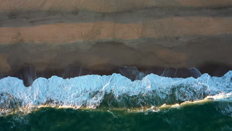 bird's view beach in uruguay waves sun down footsteps swell