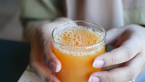 women holding a glass of orange juice