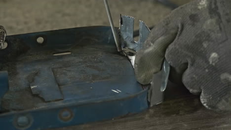 welder's hand with gloves welding a piece of metal creating sparks at an industry workshop - close up, macro shot