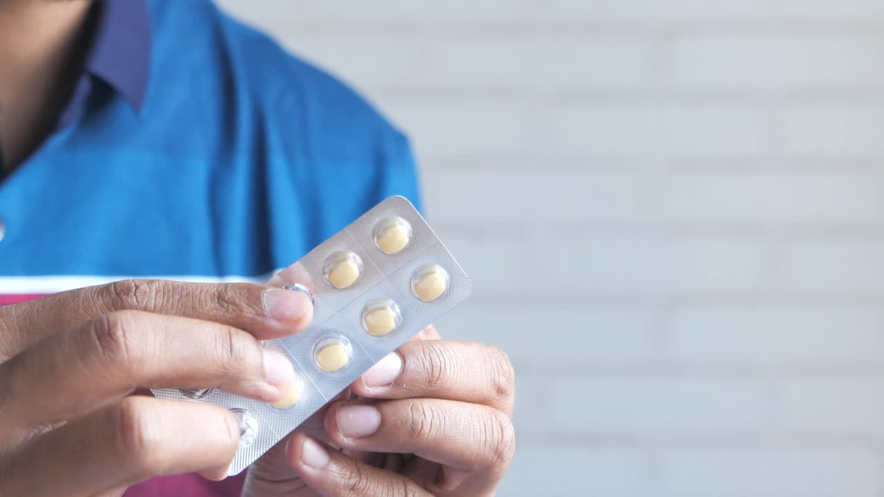 Man Holding a Blister Pack of Pills