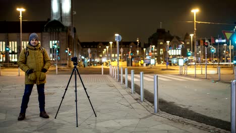timelapse de la calle nocturna con un hombre disparando video. helsinki, finlandia