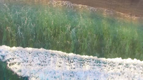 waves crashing over reef aerial view