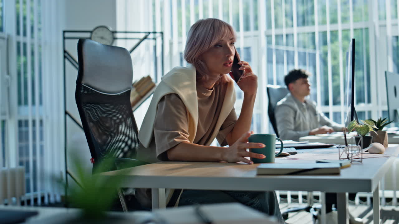 Closeup businesswoman smartphone call at workplace. Relaxed woman drinking tea