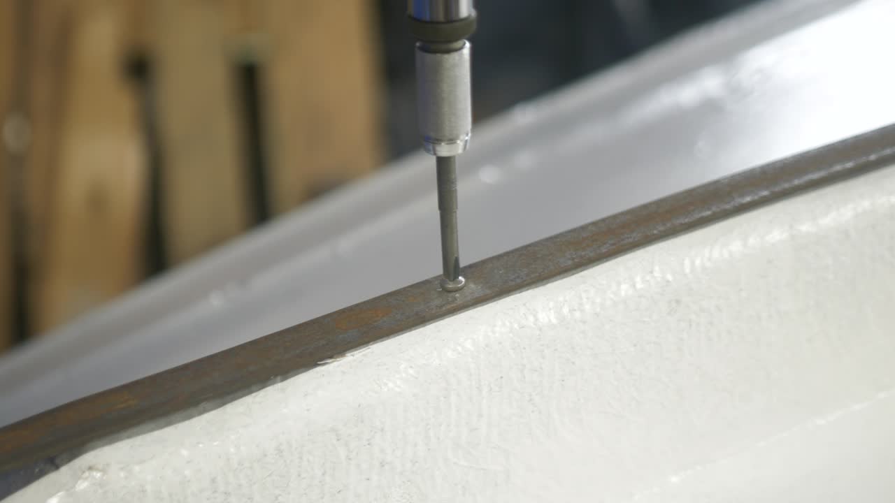 Befestigung eines Kielbands aus Stahl an einem Glasfaserboot mit Edelstahlschrauben.
