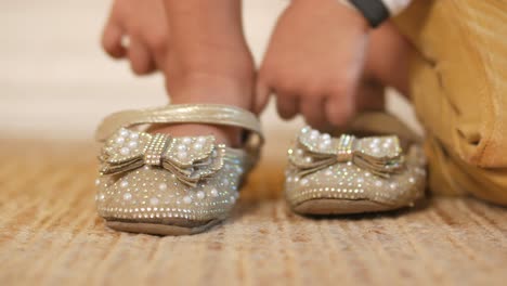 child putting on sparkly decorated shoes