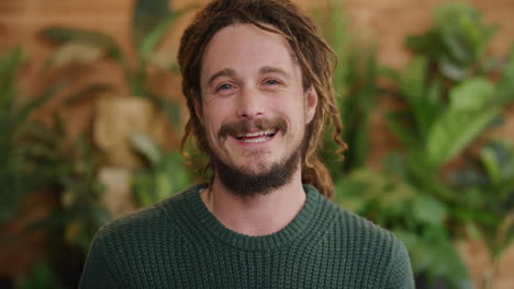 retrato de un joven lindo sonriendo disfrutando del éxito satisfacción del estilo de vida hombre caucásico con rastas peinado cámara lenta