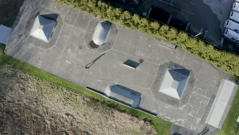 vista aérea giratoria de un patinador solitario en un skatepark vacío