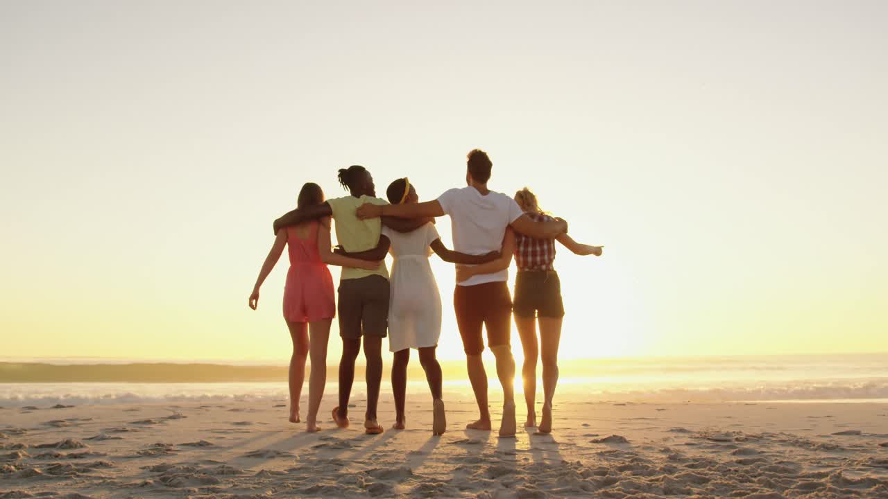 해가 지는 해변에서 휴식을 취하는 젊은 성인 친구들 4k