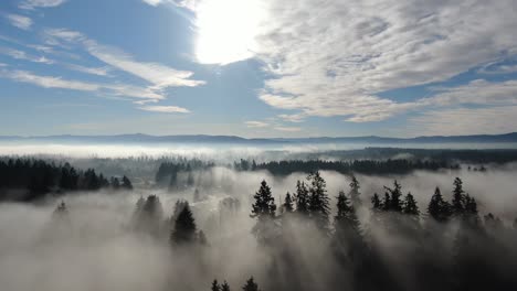 Drohnenflug-Am-Frühen-Morgen-über-Neblige-Felder-Mit-Blauem-Himmel-Und-Bergen-Im-Hintergrund