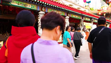 people walking towards temple entrance in hong kong