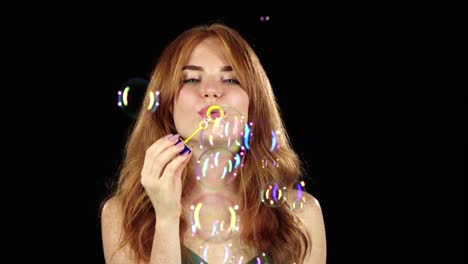 girl lets the soap bubbles black background girl lets multicolored soap bubbles and sincere smiles black background