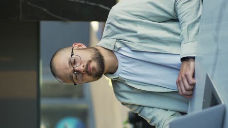 smiling businessman working on laptop computer at home office. male professional typing on laptop keyboard at office workplace