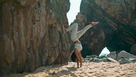 Mujer-De-Pie-Con-Las-Manos-Practicando-Yoga-En-La-Orilla-Del-Mar-De-Arena.-Chica-Entrenando-Fuerza.