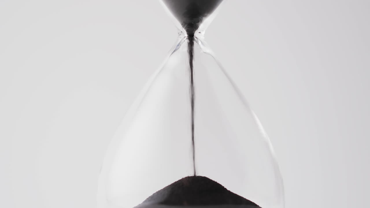 Video of hourglass with sand pouring, copy space on white background