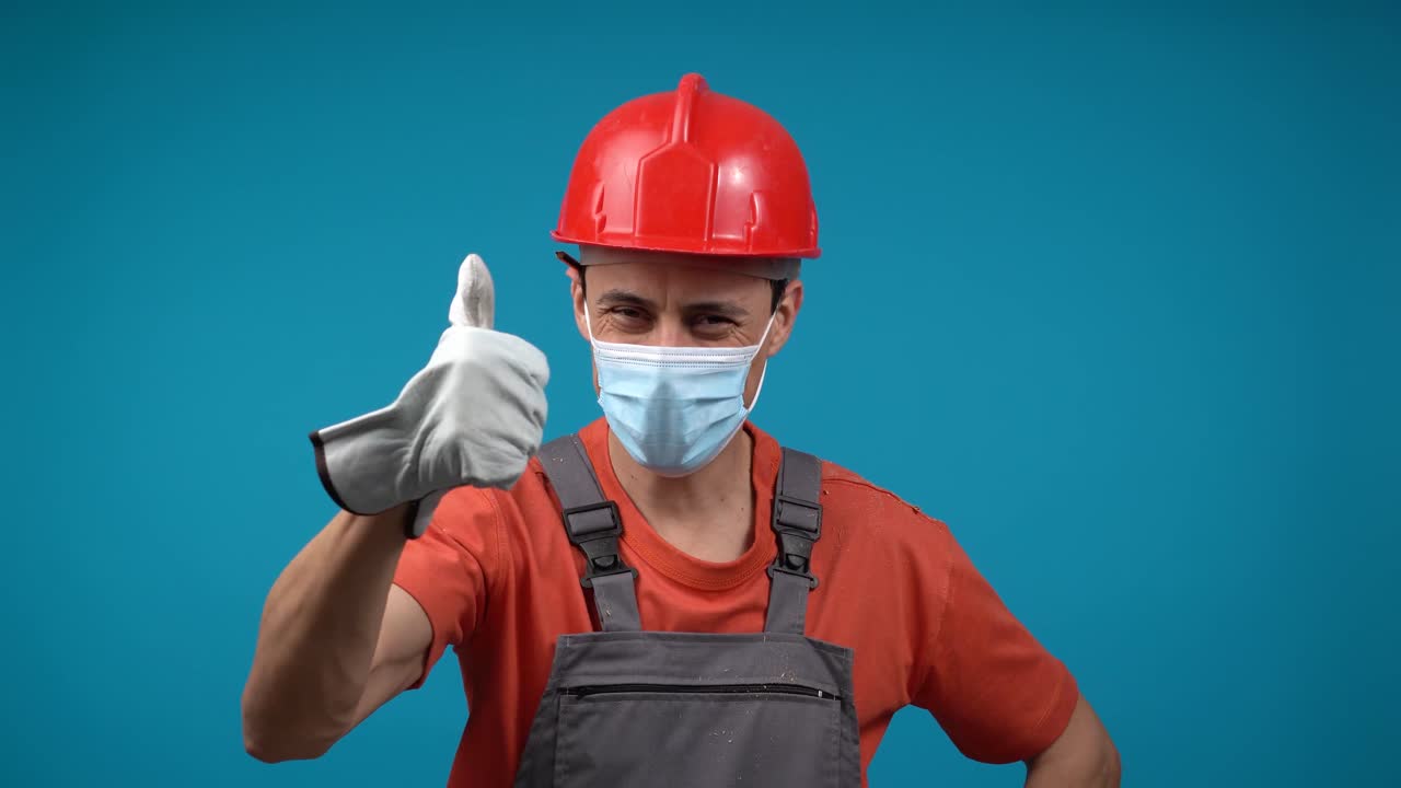 Construction Worker in Hard Hat and Medical Mask Giving Thumbs Up