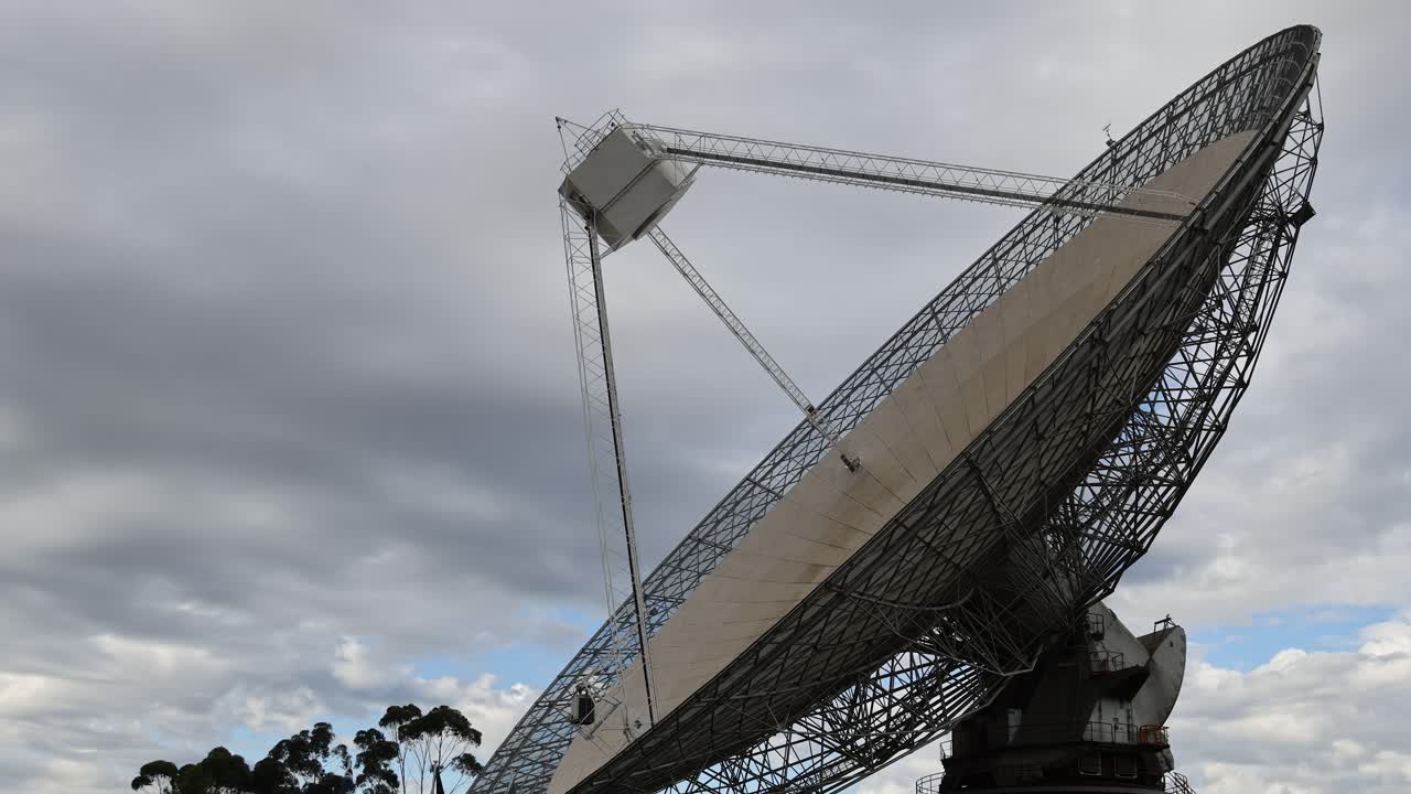 라디오 망원경이 구름이 가득한 하늘 아래로 회전합니다.