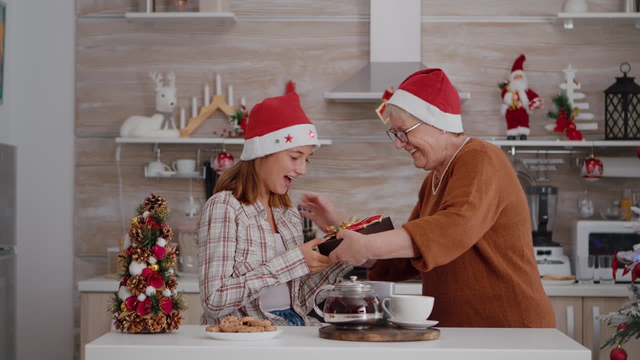 abuela sorprendiendo a su nieta con un regalo de envoltura durante las tradicionales vacaciones de invierno