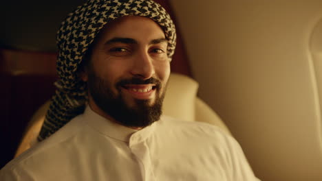 smiling arabic man posing at airplane window closeup. happy businessman travel