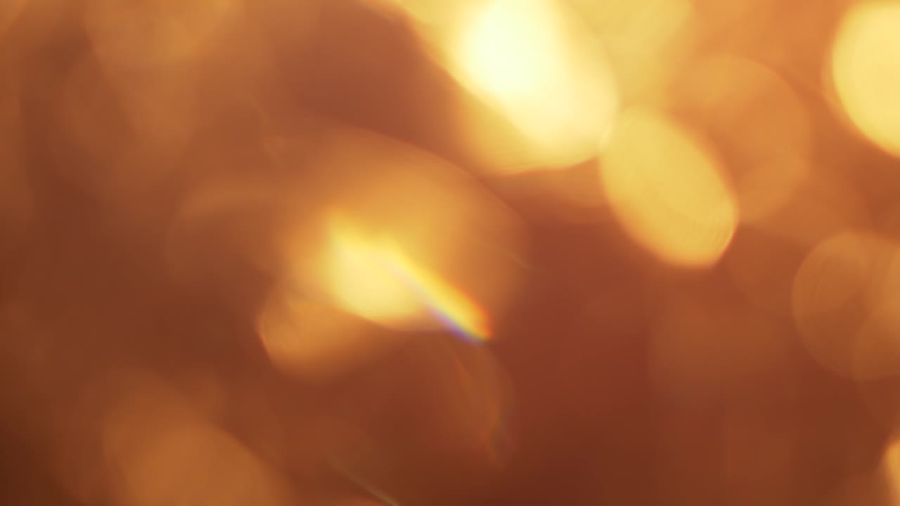 Varme gyldne bokeh-lys toner ind og ud.