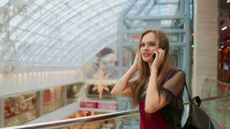 beautiful-girl-talking-on-smartphone-and-sitting-with-shopping-bags-in-mall