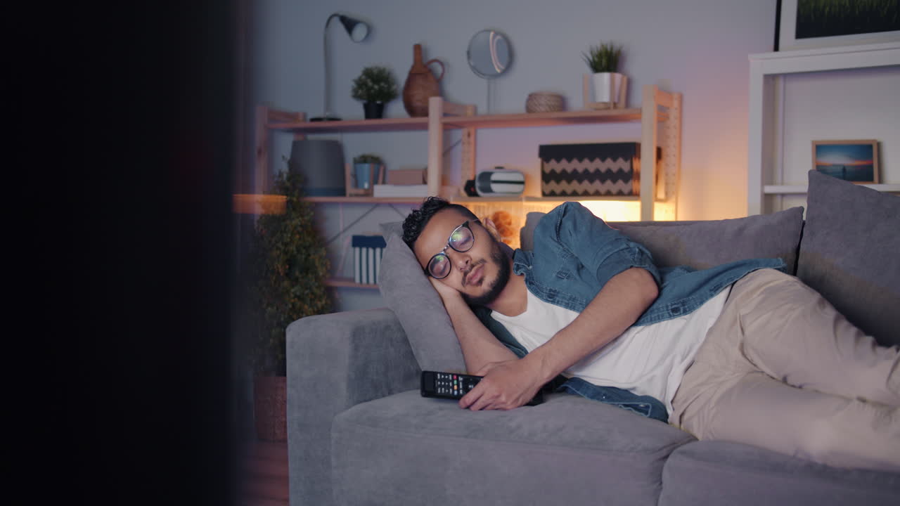 Man Sleeping on Couch While Watching TV