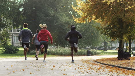 group of runners running in park wearing wearable technology connected devices