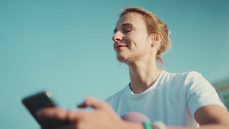 Mujer-Deportiva-Sonriente-Usando-El-Teléfono-Al-Aire-Libre.