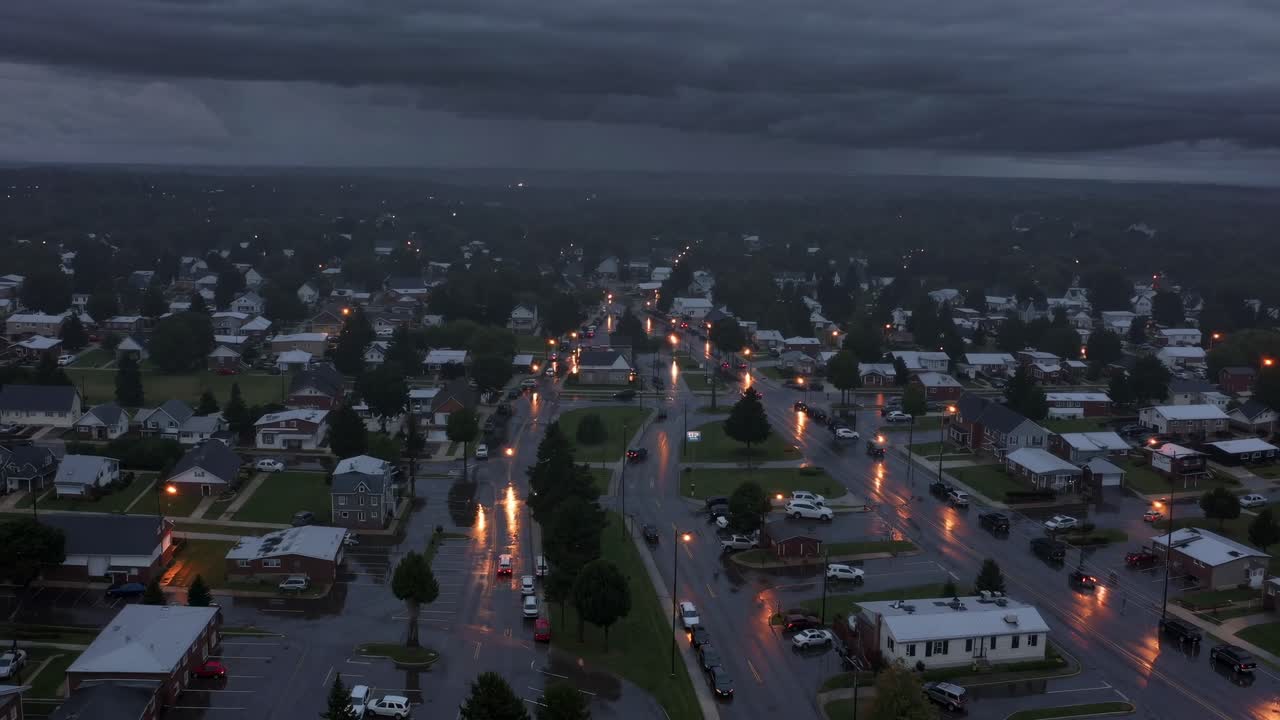 불길한 폭풍우 구름이 교외 동네 위에 떠다니며, 거리 조명들이 은 도로에 빛을 내며, 극적인 날씨 분위기와 함께 분위기적인 저녁 풍경을 만들어, 비가 부드럽게 떨어집니다.