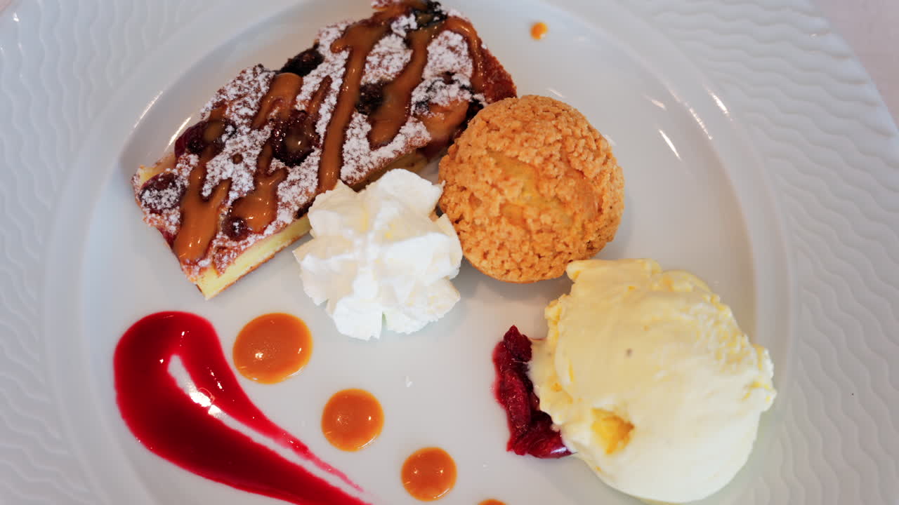 Close up of a dessert plate with a tart, a cream puff, ice cream, and sauces