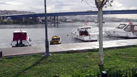 istanbul riverfront park with boats and bridge