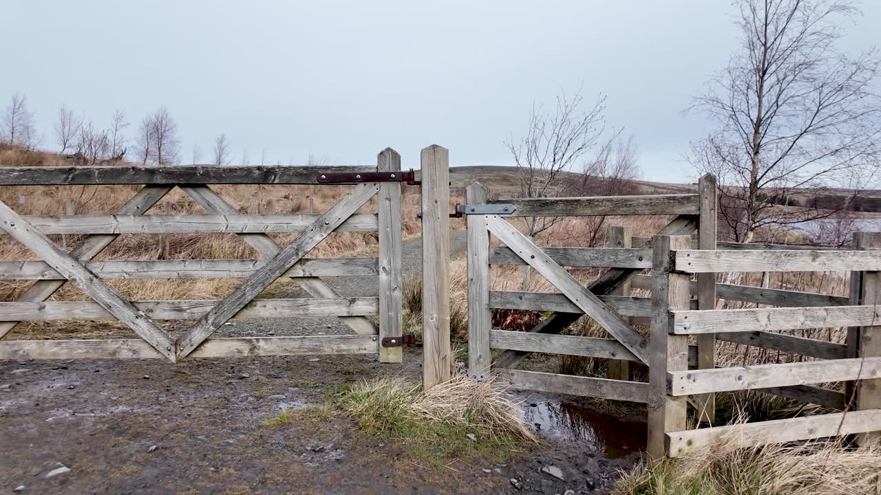 Cancello di recinzione in legno rurale che custodisce un sentiero nella campagna inglese naturale. Ripresa in avanzamento.