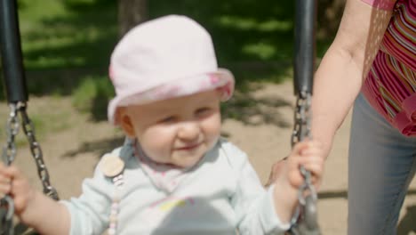 serious baby girl swinging on the teeter swing slow motion