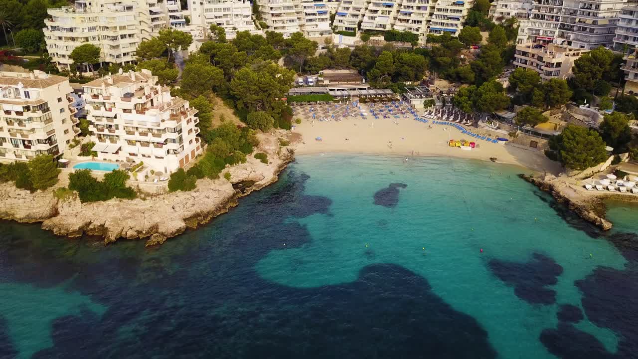 Playa Illetas con acque cristalline turchesi e bagnanti sulla spiaggia, Maiorca, Spagna, vista aerea
