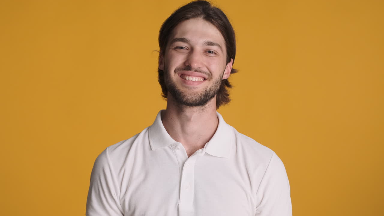 Caucasian man making ok gesture on yellow background.