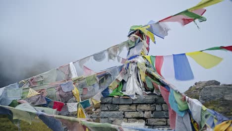 banderas de oración budista en las montañas brumosas de nepal, banderas de oración tibetanas coloridas en la niebla en los himalayas soplando en el viento en annapurna, colorido símbolo religioso del budismo en la naturaleza