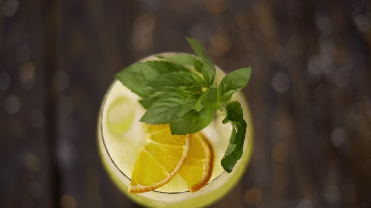 Lasillinen keltaista mintulla maustettua limonadia puupinnalla