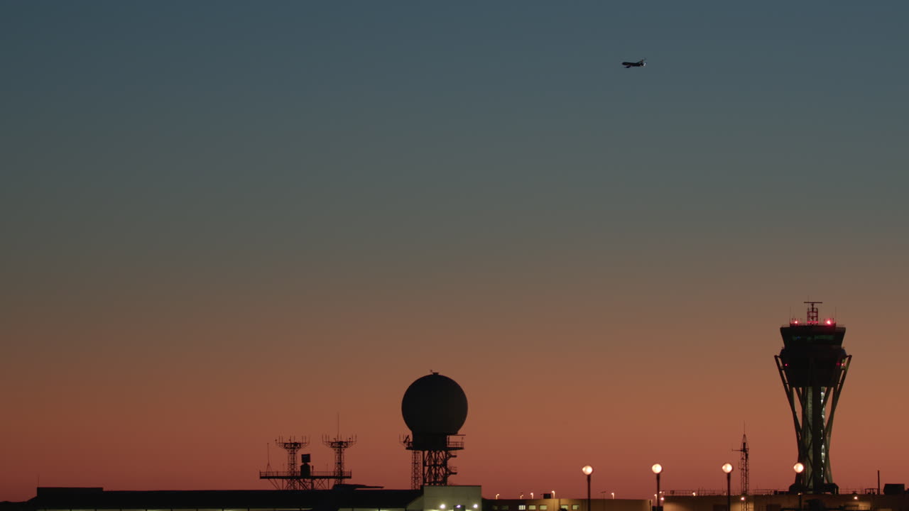 avión despegando al atardecer sobre la torre de control del aeropuerto