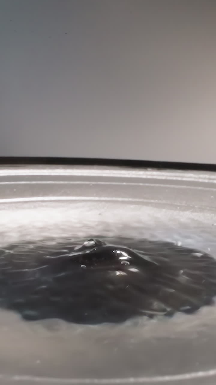 Liquid hyaluronic acid shaking due to frequencies of loud speaker while playing music. Slippery substance bubbling and reflecting bright light macro