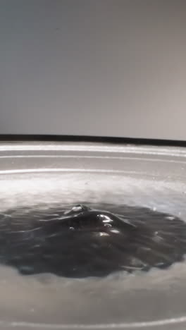 liquid hyaluronic acid shaking due to frequencies of loud speaker while playing music. slippery substance bubbling and reflecting bright light macro