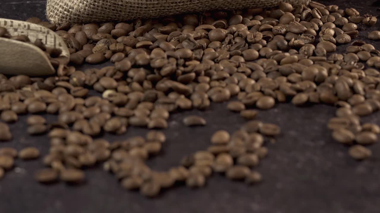 Chicchi di caffè tostati in sacco di iuta con paletta di legno
