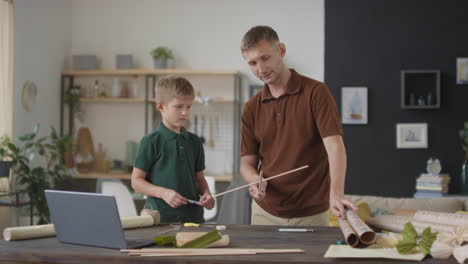 father and son making a craft project together