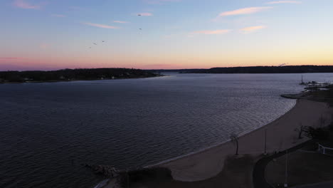 an-aerial-shot-over-an-empty-park-looking-at-the-bay-during-a-beautiful-sunrise