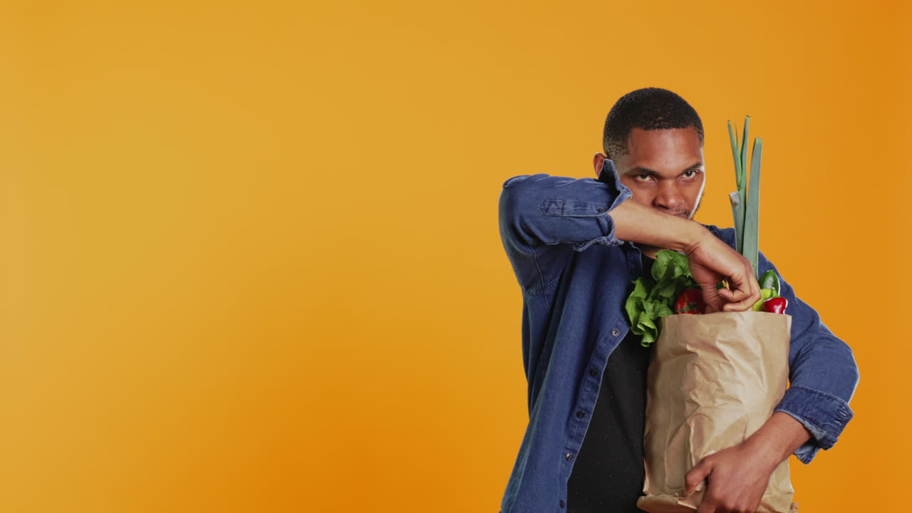 Happy young man advertising organic locally grown fruits and veggies