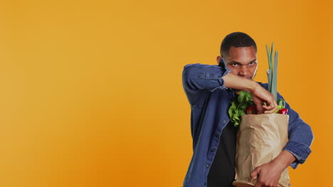 joven feliz anunciando frutas y verduras orgánicas cultivadas localmente