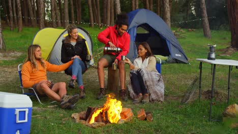 Freunde-Trinken-Kaffee-Am-Lagerfeuer-Im-Wald-4k