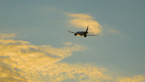 El-Avión-A-Reacción-Sube-Al-Cielo-Del-Atardecer-Con-Nubes-Naranjas.