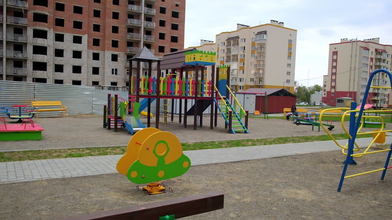 Parquinho em uma cidade com prédios de apartamentos em construção
